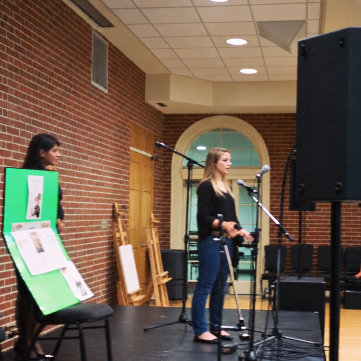 Kasha speaking on stage, viewed from the side